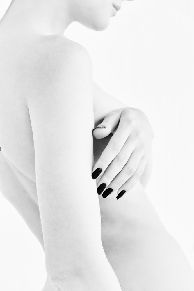 body parts of a naked girl torso and hand pressing her breasts with a black manicure on her nails from Alexandr