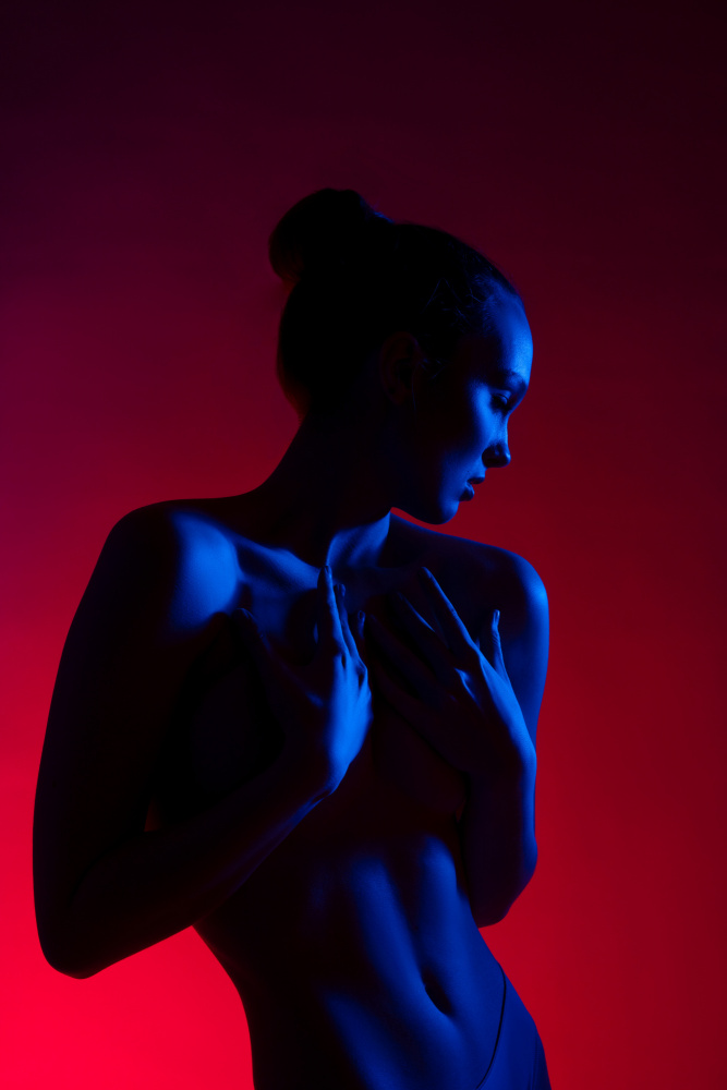 Young woman in casual clothes standing under neon light from Andrey Guryanov