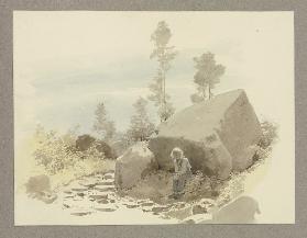 Junge bei einem Felsen sitzend