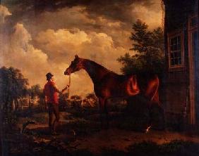 A hunter and groom outside a country house