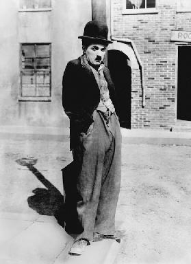 A dog 's life by and with Charlie Chaplin , standing in a street, hands in pockets. Los Angeles