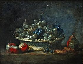 Still life: grape basket with three apples, a pears and two marzipans