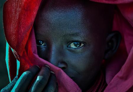 Ethiopian child covered in a red robe.