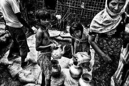 Rohingya people drawing water from a pit - Bangladesh