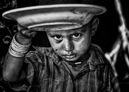 Sad Rohingya refugee child showing me his empty plate of food.