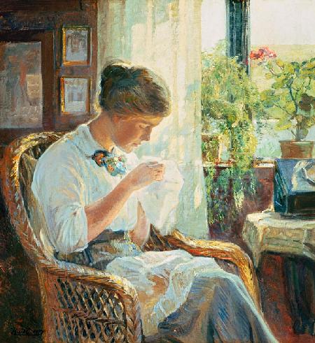 Sewing young woman at the window
