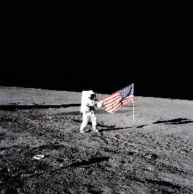 Apollo 12 Astronaut Charles Pete Conrad stands beside the United States flag after is was unfurled o