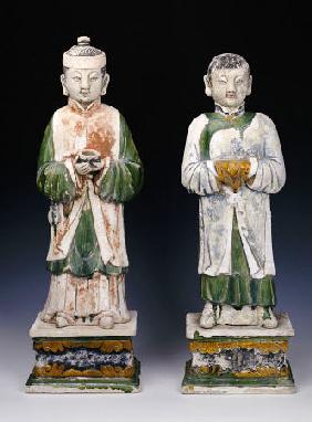 An Unusual Pair Of Glazed And Painted Pottery Figures Of Attendants
