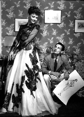 fashion designer Oleg Cassini showing his drawings to Gene Tierney to show her the clothes for film 
