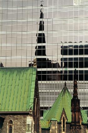 Green roofs and church reflected in glass panels (photo) 