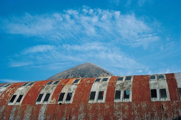 Rusted roof of a deserted warehouse with the breast of a mountain (photo)  from 