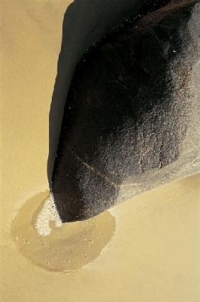 Unusual rock formation pointing a puddle on sand Vishakapatnam (photo) 