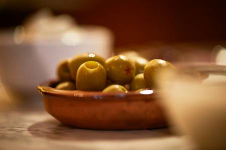 Drei Schalen mit Oliven auf einem Esstisch