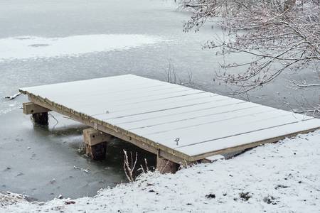 Holzsteg im zugefrorenen See