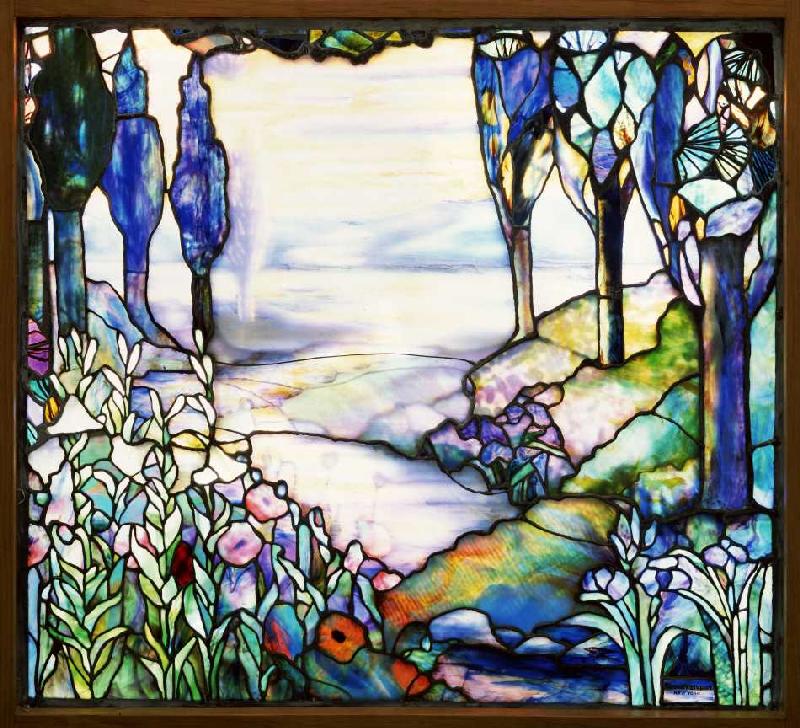 Flusslandschaft mit Blick auf eine Bergkette im Zwielicht mit Zypressen, Lilien, Mohnblumen und Iris from Tiffany Werkstatt